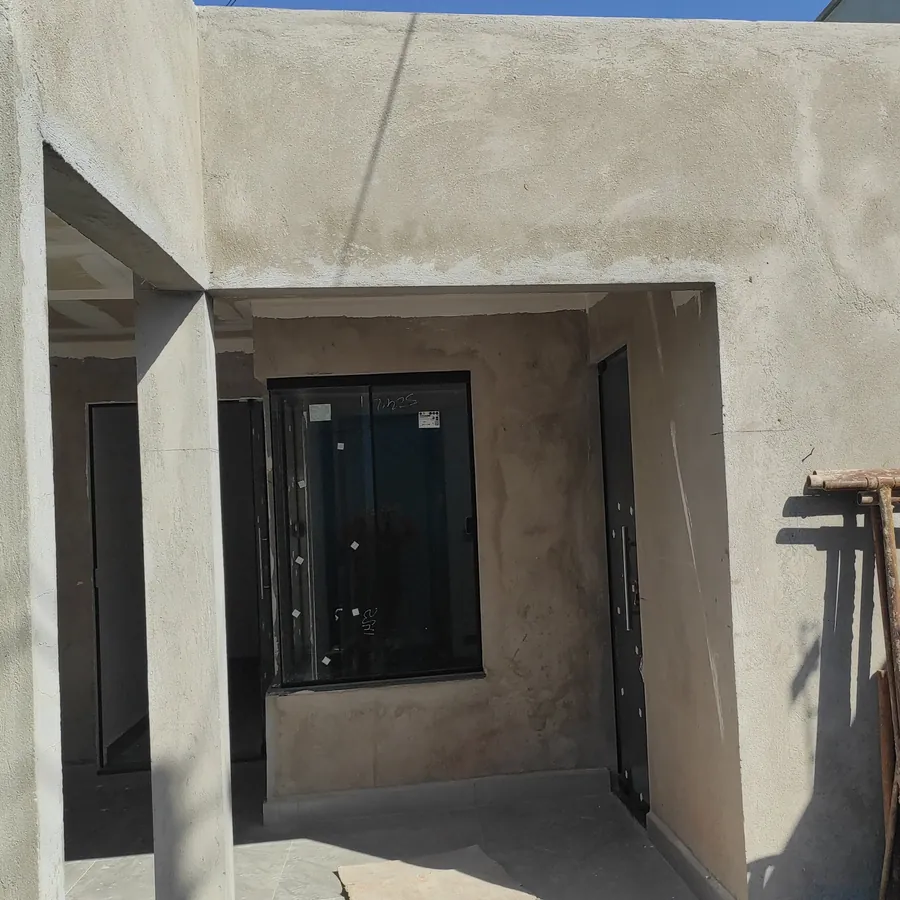 Fachada da mesma casa rebocada, com esquadria instalada