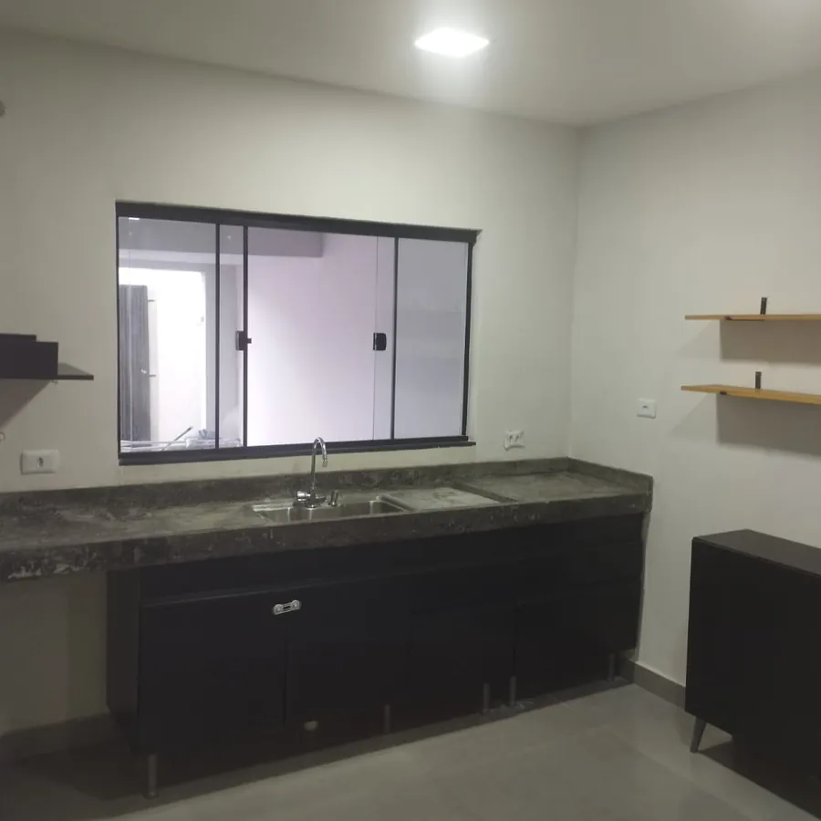 Cozinha da casa entregue, com bancada e prateleiras